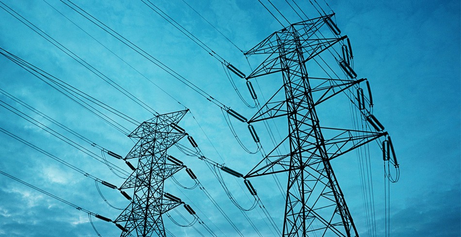 Electricity transmission towers set against bright blue sky (cyber energy)