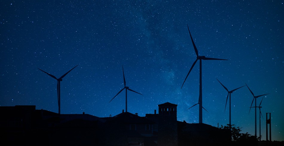 Wind turbines against dark blue night sky (capacity mechanism)