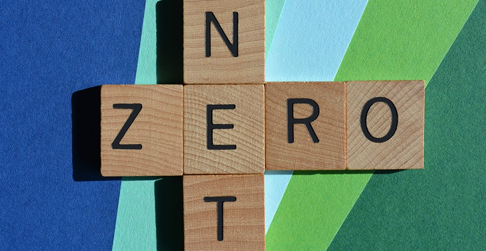 Scrabble tiles spell Net Zero on blue and green background