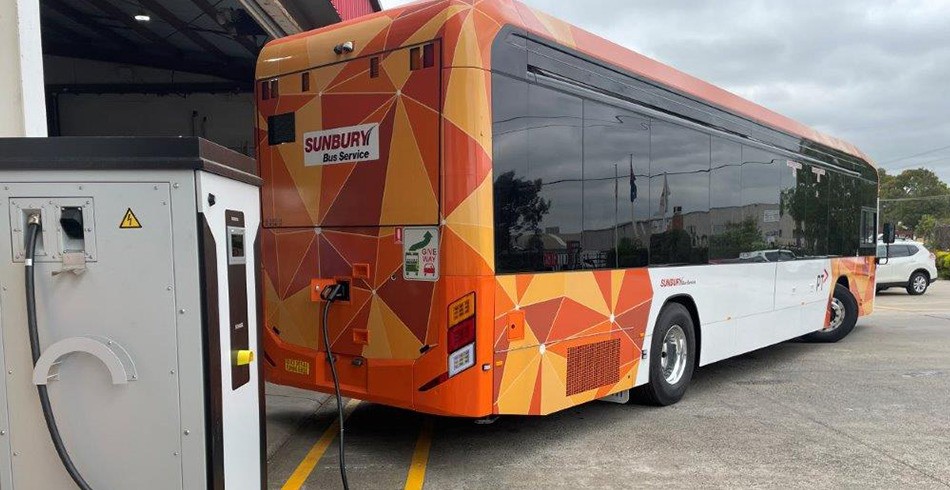 Orange zero-emissions bus connected to charging station (siemens)