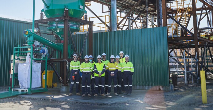 Staff in high-visibility clothing stand outside Hazer's commercial demonstration plant (hazer capital)