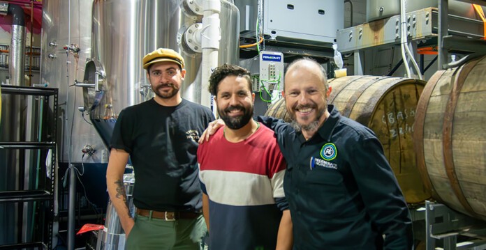 Three men smiling with brewing equipment in 3 Ravens brew hall (brewer)