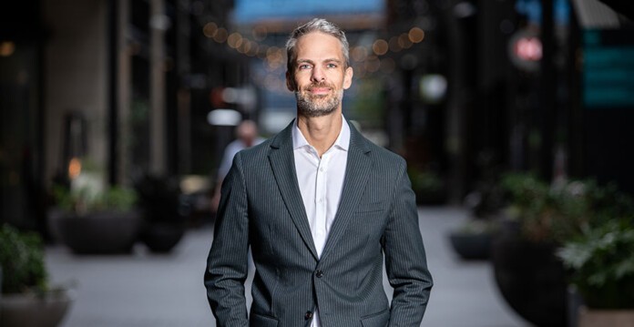 Nathan Gower, director of Boomi in Australia and New Zealand, stands wearing suit in a retail laneway