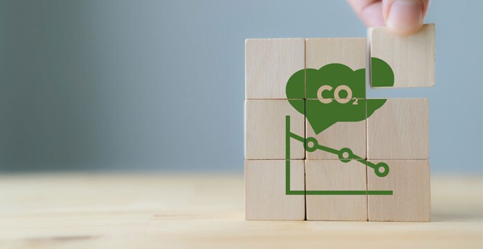 CO2 concept image showing hand placing painted blocks into a formation that shows a CO2 cloud and molecule (hub)