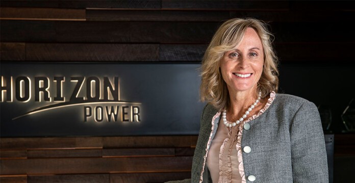 Horizon Power CEO Stephanie Unwin smiles while standing in front of Horizon Power signage (energy vault)