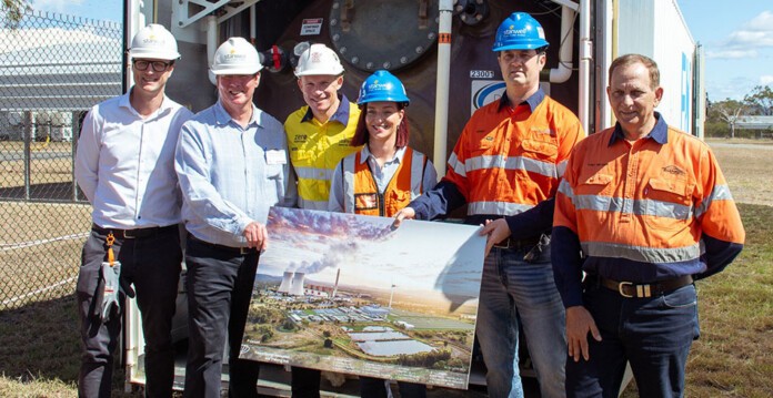 Smiling group of officials in high-vis gear and hard hats stand with artist's impression of project (Stanwell ESI)