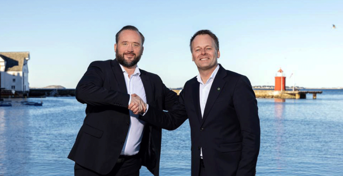 Two smiling executives in suits shake hands with waterfront in background (norwegian fortescue)