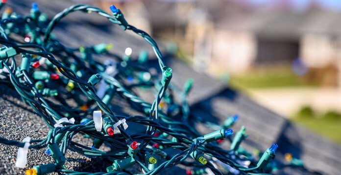 Tangled Christmas lights on roof with homes in the background (safety)