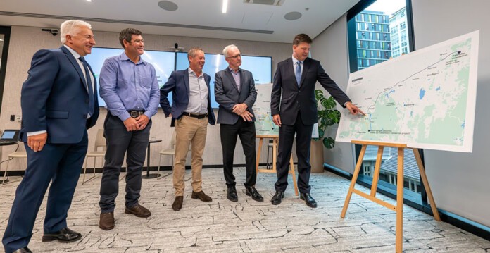 Energy executives from Genus, ACCIONA and Transgrid look at map of the HumeLink transmission project
