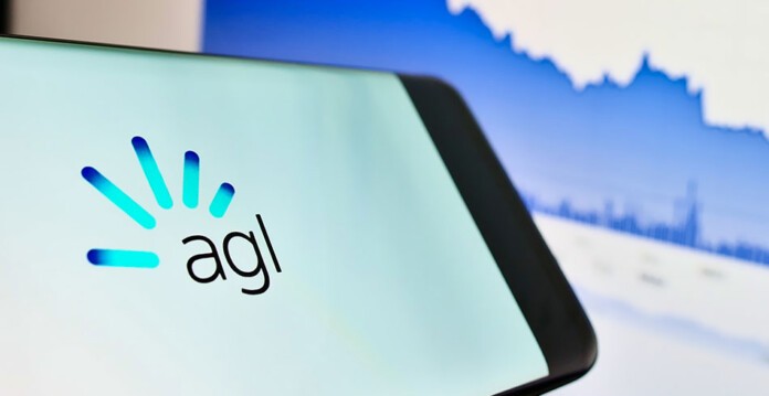 AGL logo displayed on smartphone with graph on computer screen in background (profit)